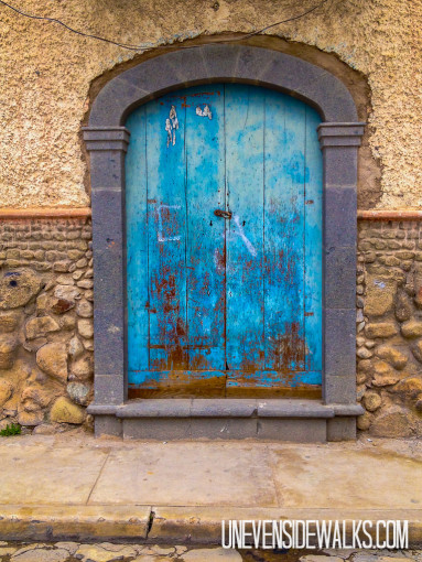 Blue arched door that's pretty beat up